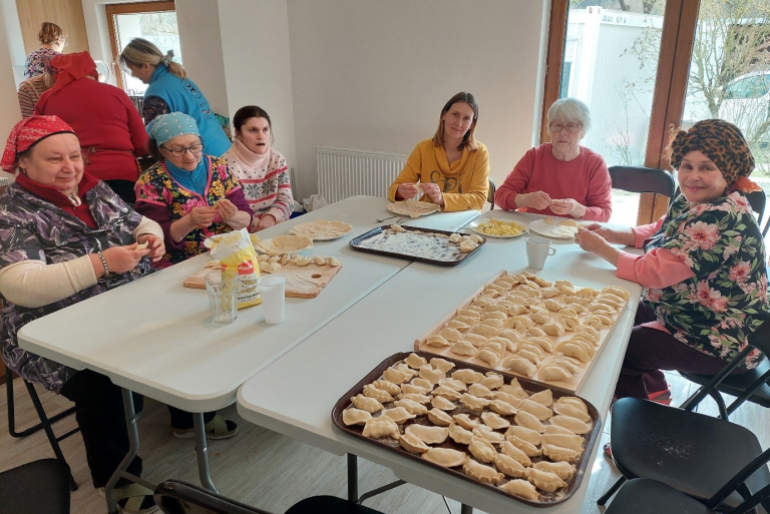 Frauen aus der Ukraine bereiten ein traditionelles osteuropäisches Gericht zu: Pierogi (Teigtaschen gefüllt mit Kartoffeln und Sauerkraut).