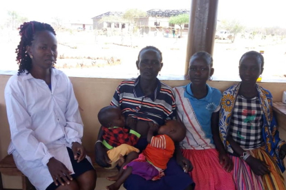 Gesundheitshelferin Catherine Aloko (links) nimmt sich Zeit für die Untersuchung der Zwillinge Esther und Rotich Daudi (Mitte). Der Zustand der Kinder ist ernst. Im Hintergrund ist der Rohbau des zentralen Klinikgebäudes in Kosike zu sehen.